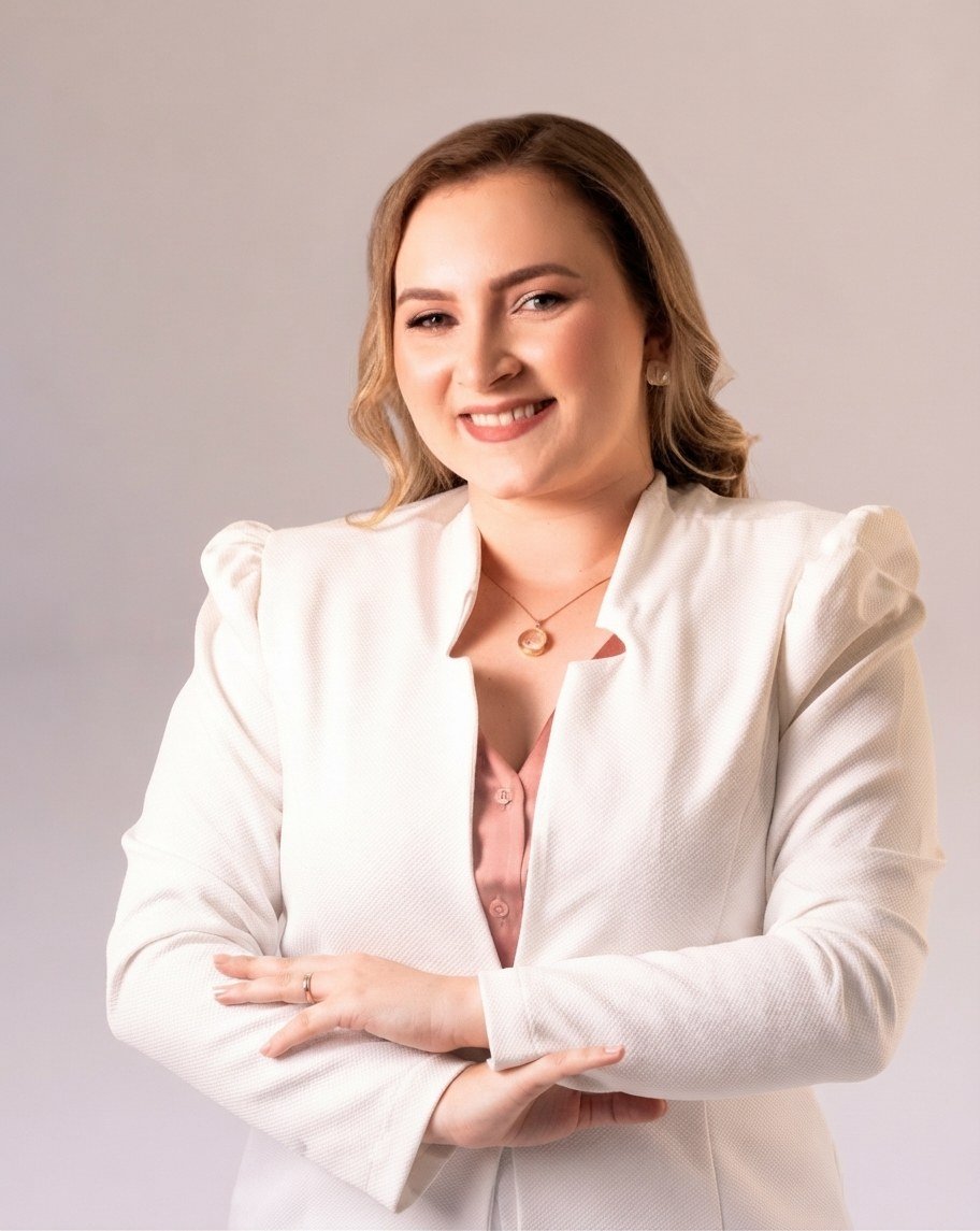 Thaís Melo sorrindo, de blazer branco